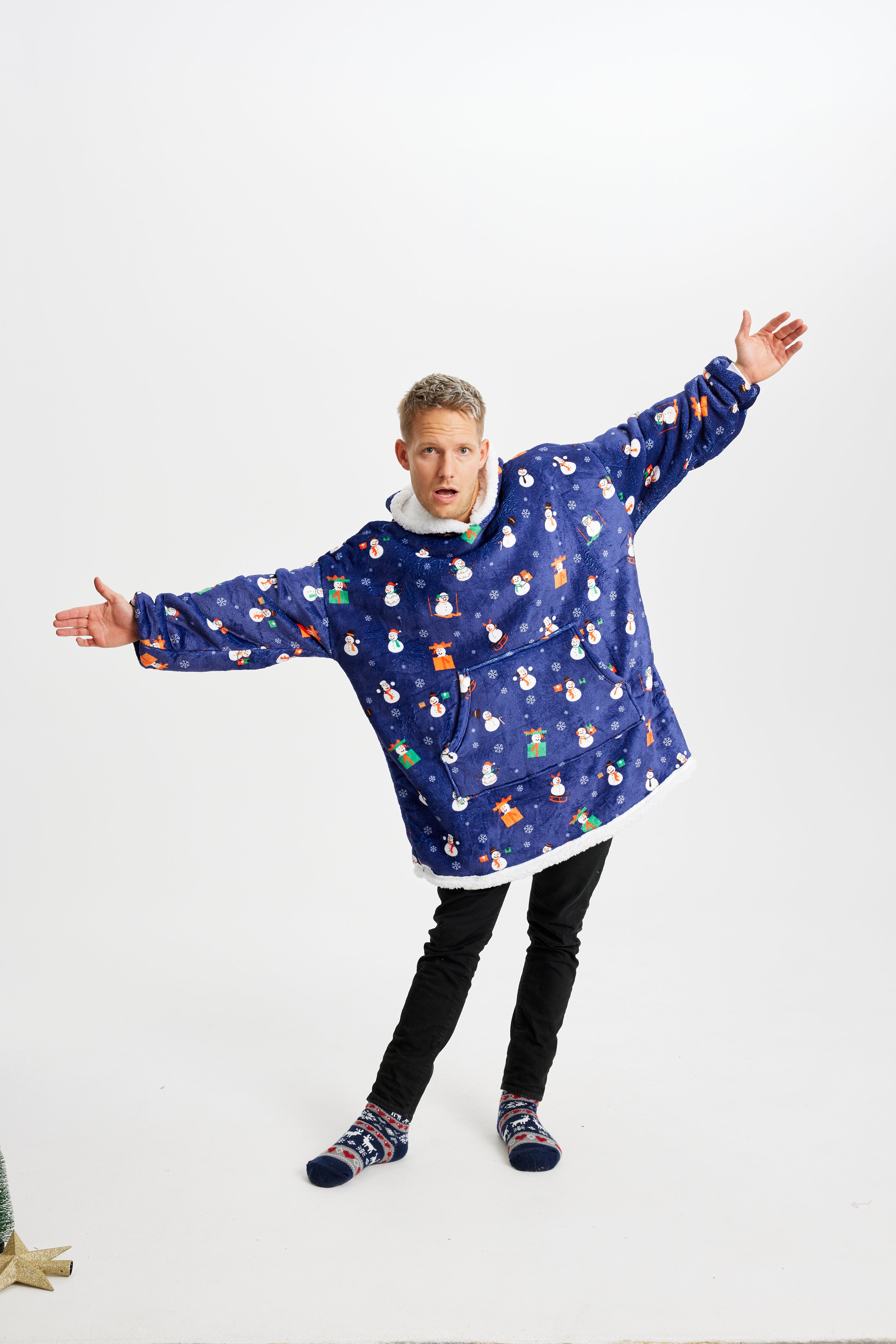 Un uomo in posa che indossa una felpa natalizia blu con cappuccio.